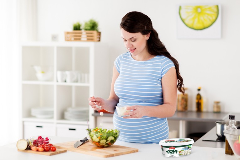 Hamile kadın yemek yapıyor.
